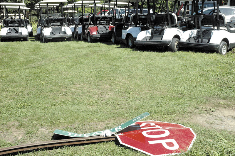 The sign for Theater Road and a stop sign lay flattened in front of a row of damaged golf carts at Lakewood Golf Course in Madison.