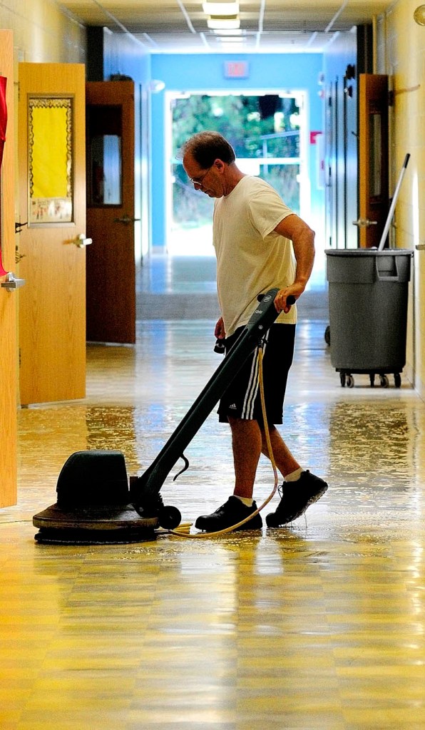 PREPARING: Matt McGowan runs a floor stripper down a hallway in James H. Bean School on Wednesday morning in Sidney. He and other staffers were getting ready for the 2012-13 school year that will begin Aug. 29.