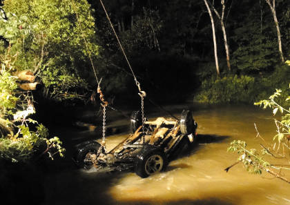 A Jeep submerged in Bond Brook in Augusta on Thursday night is towed back to shore. Police on Friday were still searching for the driver, who fled from the scene.