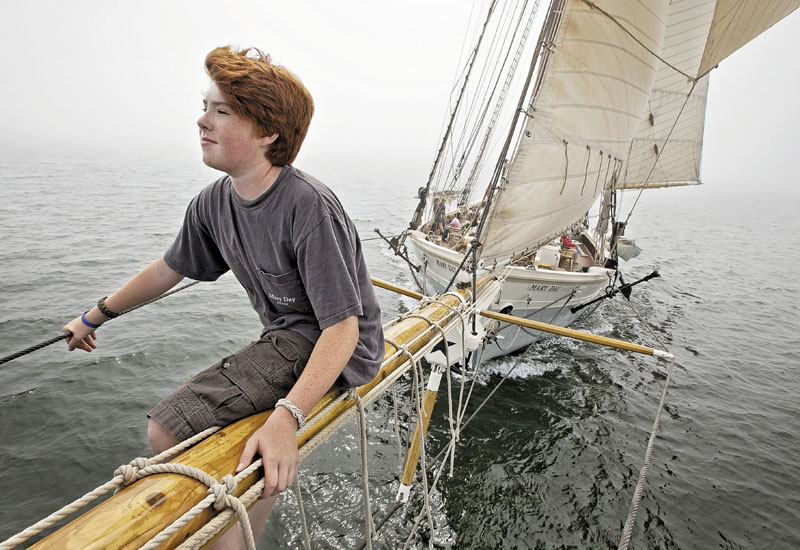 Sawyer King, 12, the son of the captain, rides on the bowsprit of the 90-foot passenger schooner Mary Day, while sailing on a foggy afternoon Aug. 2 in East Penobscot Bay off Little Deer Isle. The Mary Day, which is celebrating its 50th season, is the first schooner in the Maine windjammer fleet to be built specifically to accommodate passengers. Its sleeping cabins are heated and have nine feet of headroom.
