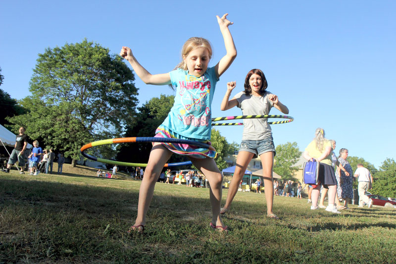 Rayvin Creamer, 7, plays with a hula hoop as her aunt Cassidy Hartin, 12, looks on at National Night Out in Waterville on Tuesday. The annual event was hosted by the Waterville Police Department, the South End Neighborhood Association and the South End Teen Center.