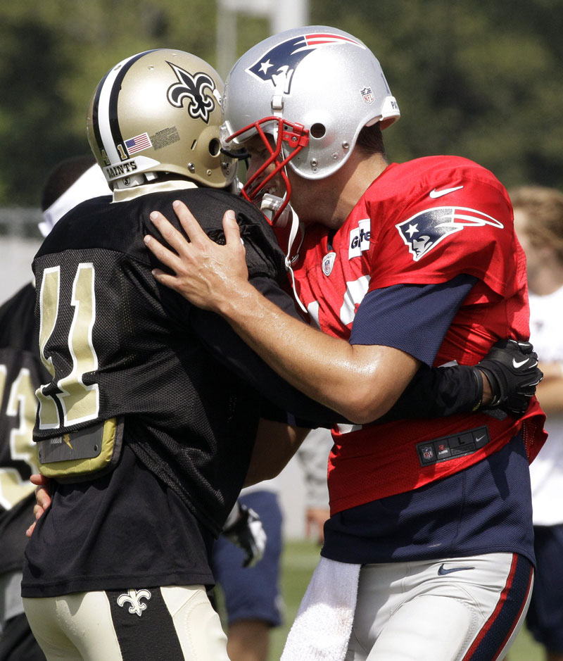 HEY BUDDY: New England Patriots quarterback Tom Brady, right, greets New Orleans Saints safety Roman Harper during a joint practice Tuesday in in Foxborough, Mass.