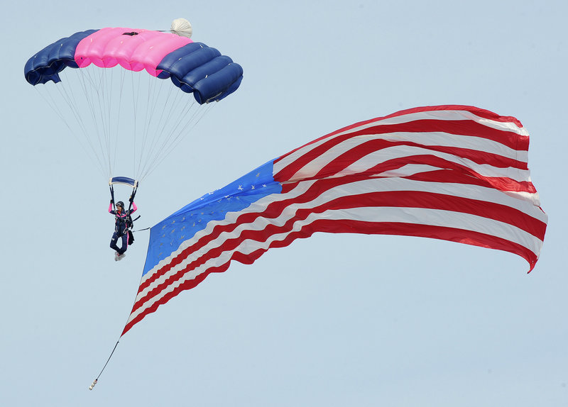 A member of the Misty Blues all-woman skydiving team trails the American flag during the opening ceremony at The Great State of Maine Air Show in Brunswick on Saturday.