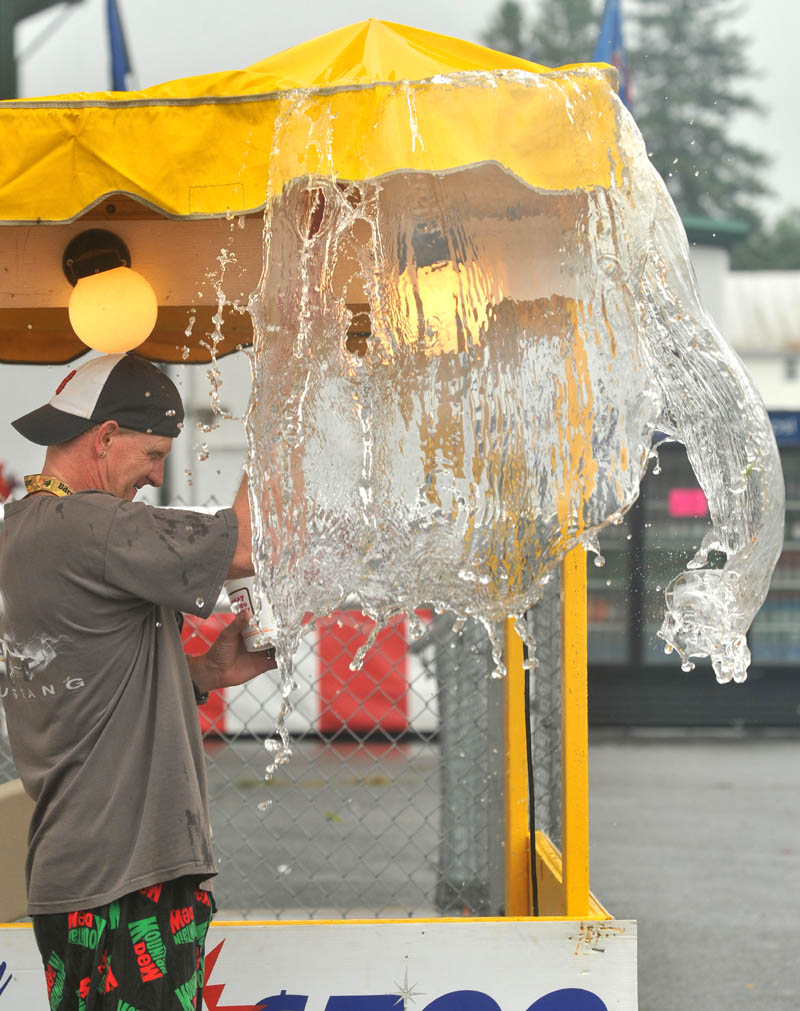 Greg Smith clears water from the ticket tents at the Skowhegan State Fair Friday morning.