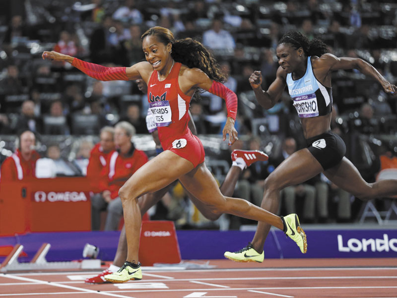 GOLDEN MOMENT: United States’ Sanya Richards-Ross, left, crosses the finish line to win gold ahead of Botswana’s Amantle Montsho, right, in the women’s 400-meter final Sunday in London. 2012 London Olympic Games Summe