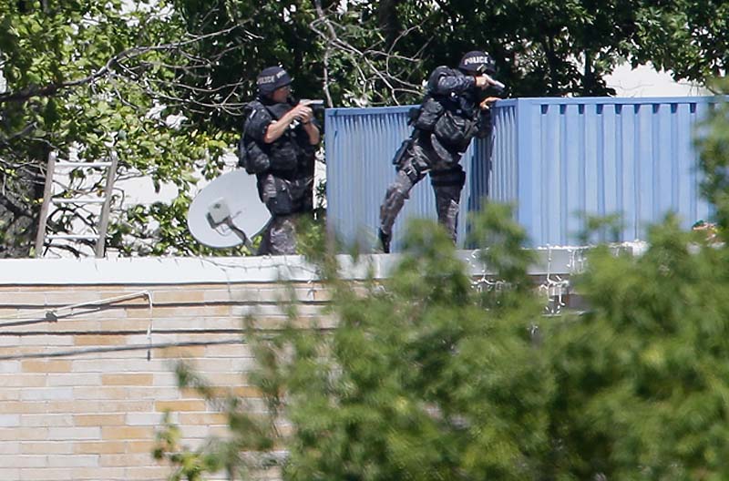 Armed police investigate the Sikh temple in Oak Creek, Wis., where a shooting took place on Sunday.