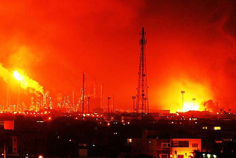 Fire rises over the Amuay refinery near Punto Fijo, Venezuela, Saturday. A huge explosion rocked Venezuela's biggest oil refinery, killing at least 24 people and injuring dozens, an official said.