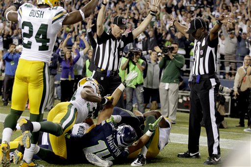 Officials signal a touchdown by Seattle Seahawks wide receiver Golden Tate, obscured, on the last play of an NFL football game against the Green Bay Packers, Monday, Sept. 24, 2012, in Seattle. The Seahawks won 14-12. (AP Photo/Stephen Brashear) NFLACTION12;