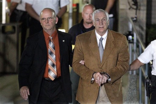 FILE - In this June 22, 2012 file photo, former Penn State University assistant football coach Jerry Sandusky, center, leaves the Centre County Courthouse in custody after being found guilty of multiple charges of child sexual abuse in Bellefonte, Pa Sandusky has been recommended for designation as a sexually violent predator, a legal status that would require lifetime registration with authorities, according to a person who has read an assessment board's report to a judge in the case. The recommendation from the Sexual Offenders Assessment Board was disclosed to The Associated Press on Thursday, Aug. 30, 2012 by the person, who spoke on condition of anonymity because of the report's confidential nature. (AP Photo/Gene J. Puskar, File)