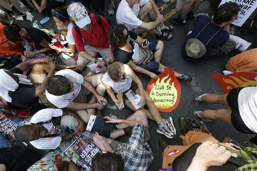 Demonstrators sit in an intersection during a protest march, Sunday, Sept. 2, 2012, in Charlotte, N.C. Demonstrators are protesting before the start of the Democratic National Convention. (AP Photo/Patrick Semansky)