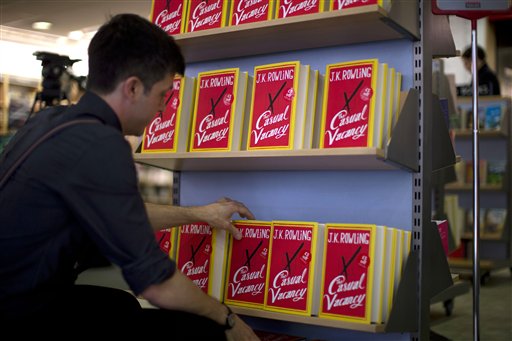An employee adjusts copies of "The Casual Vacancy" by author J.K. Rowling at a book store in London, Thursday, Sept. 27, 2012. British bookshops are opening their doors early as Harry Potter author J.K. Rowling launches her long anticipated first book for adults. Publishers have tried to keep details of the book under wraps ahead of its launch Thursday, but "The Casual Vacancy" has gotten early buzz about references to sex and drugs that might be a tad mature for the youngest "Potter" fans. (AP Photo/Matt Dunham)
