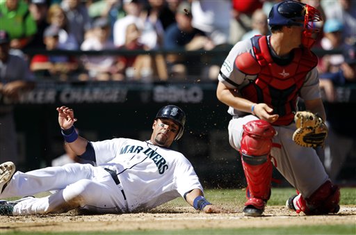 Seattle Mariners' Franklin Gutierrez, left, scores ahead of a tag by Boston Red Sox catcher Ryan Lavarnway in the fourth inning of a baseball game, Monday, Sept. 3, 2012, in Seattle. (AP Photo/Elaine Thompson) Safeco Field