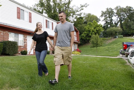 Marine Sgt. Ron Strang, right, walks with his girlfriend, Monica Michna, in the yard by his home in Jefferson Hills, Pa., just south of Pittsburgh. The 28-year-old former Marine sergeant from Pittsburgh lost half of his left thigh muscle to shrapnel. Now, after an experimental cell treatment at the University of Pittsburgh Medical Center, "I'm able to run a little bit" and play a light football game with friends, he said.