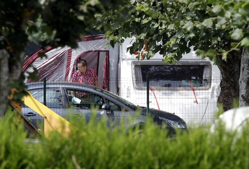 An investigator enters the trailer where the slain British family were holidaying in a camp site of Saint Jorioz, near Annecy, France Thursday, Sept. 6, 2012. A 4-year-old British girl hid for eight hours beneath the bodies of slain family members in the back of their car in a nearby forest, before she was discovered by French investigators who had been guarding the vehicle, a prosecutor said Thursday. Three people — a man and two women — had been shot to death, as was a French cyclist whose body was found nearby. (AP Photo/Lionel Cironneau)