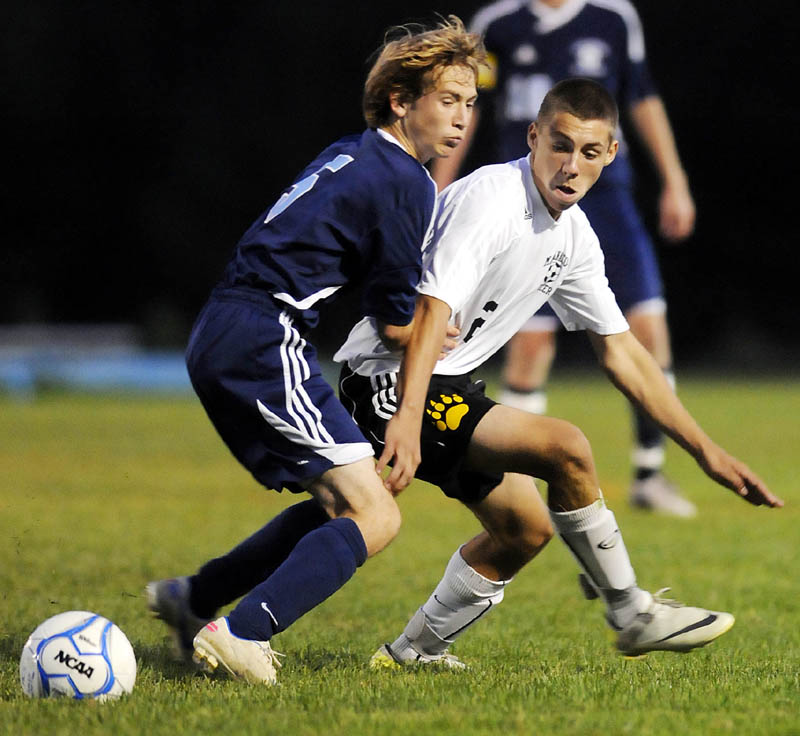 MAKE THE PLAY: Maranacook Community High School’s Andrew Poulin, right, battles for the ball with Oceanside High School’s Kaleb Robinson during the Black Bears’ 3-2 win Tuesday in Readfield.