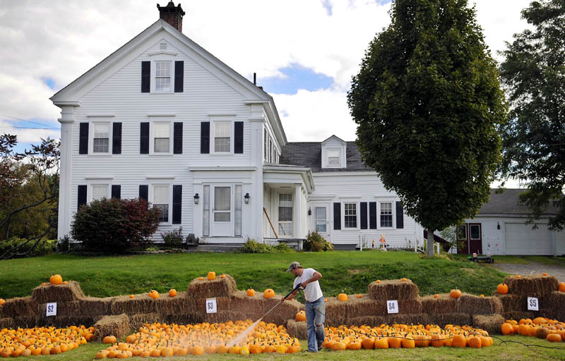 THE BIG PATCH: Jeremy Burbank washes pumpkins Monday for sale along the road at his family's farm in Vassalboro. Burbank, his wife, Lora Lei-Burbank, and their seven children cultivated approximately 1200 of the decorative gourds this season at Oak Grove Farm.