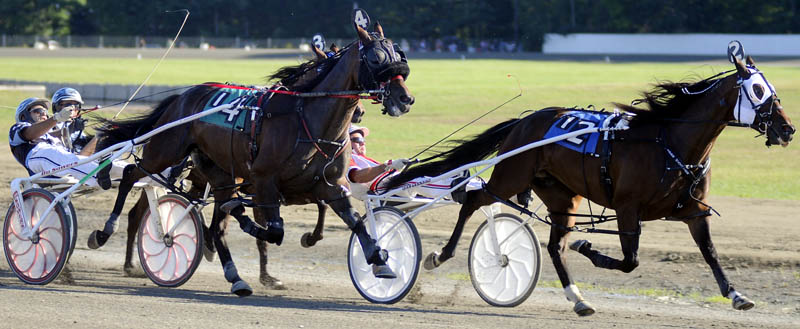 HEAD TO HEAD: Jockey Kevin Switzer Jr, left, on Malek Hanover pulls up on Kevin Switzer, center, on Mr. Nice Guy, as Jason Barlett, on Viper Hanover, tries to pull ahead Sunday during the Windsor Invitational. Kevin Switzer Jr. prevailed with Bartlett finishing second.