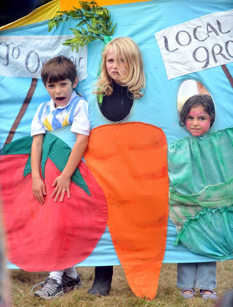 Staff photo by Michael G. Seamans Ashwood Waldorf School students, Jacob Lavi, 7,left, Louis Mainella, 8, center, and Melissa Lavi, 5, right, do their best vegetable impersonation while on a field trip to the Common Ground Fair in Unity Friday.