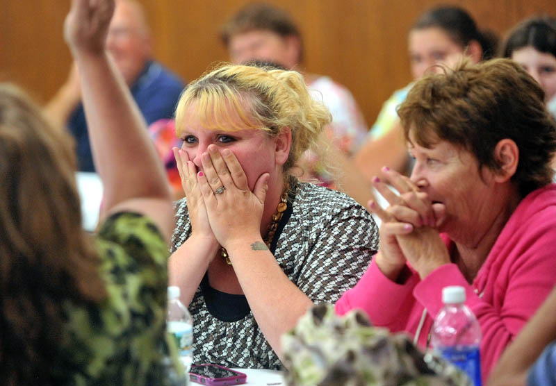 Heidy Mullen, center, reacts after her son's number was picked to fill one of the limited spots in the Cornville Charter School first grade during the lottery at the American Legion hall on Waterville Road, Skowhegan.
