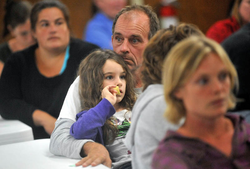 Kevin Mack, center, sits with his daughter Avery, 6, during the lottery to fill 60 slots at Cornville Charter School at the American Legion hall on Waterville Road, Skowhegan. The Macks did not have their number selected and are fourth on the waiting list.
