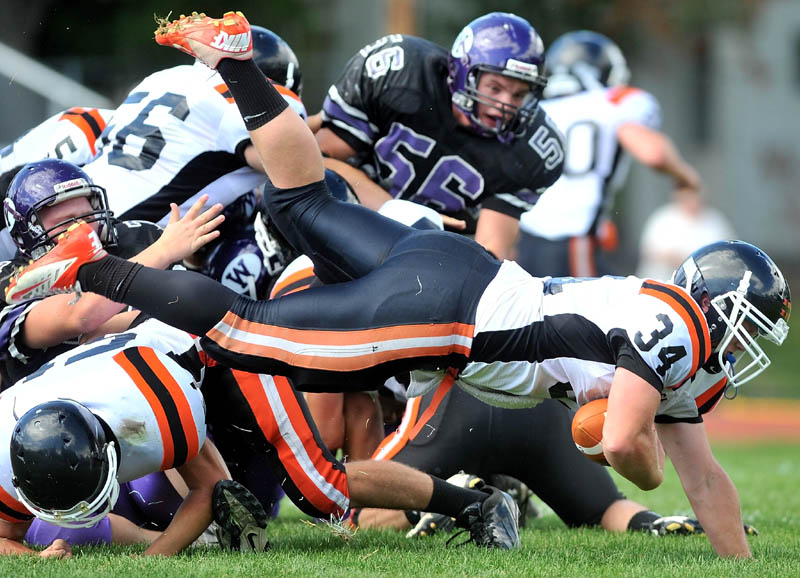 Gardiner running back Seth Wing, 34, dives over a pile of players in the second quarter against Waterville Senior High School in Waterville Saturday.
