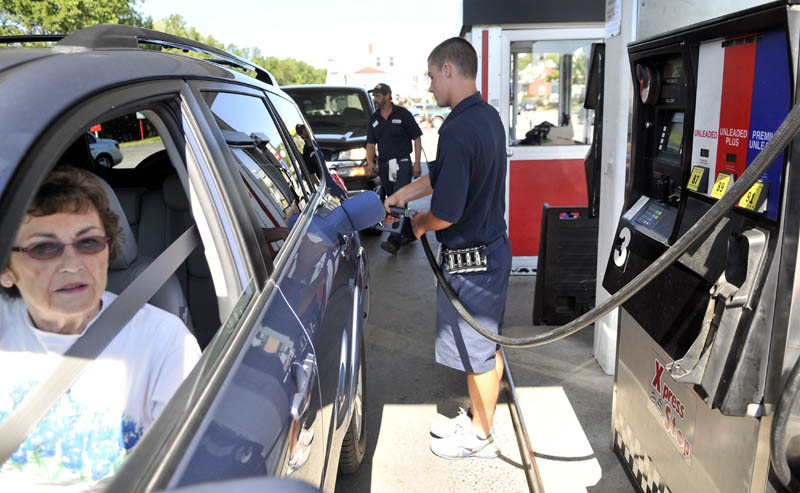 Joseph Hopkins fills the tank for Lorraine Bowdion on Saturday at J&S Oil Xpress Stop on Bay Street in Winslow.