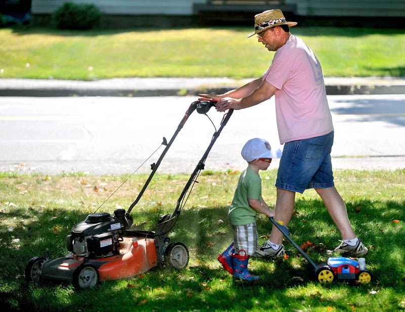 Tom Hubbard gets help mowing the lawn from his grandson Harper, 2, at his son's Mayflower Hill Road residence in Waterville Friday. Hubbard and his wife Ann are in town visitng from Vermont. Hubbard has given his son the old lawn mower and wanted one more drive.