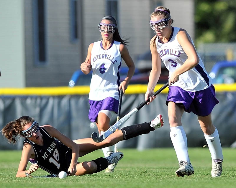 Staff photo by Michael G. Seamans Mt. Blue High School's Taylor Hollingsworth, 18, left, is knocked down as Waterville Senior High School's Kelsea Tortorella, 3, right, and teammate Gabrielle Bridger, 6, center, fight for the ball in the first half at Waterville Thursday.