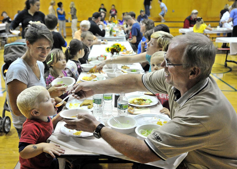 Dale "Papa" Mullin, right, feeds his grandson Boaz, 2, fresh soup while dining at the harvest dinner at Garrett Schenck Elementary School in Anson Tuesday. Most of the food served was grown in the elementary school garden by students.