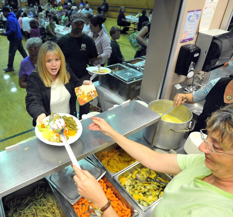 Bonnie Johnson, right, serves fresh vegetables to Sam Richardson at the Harvest dinner at Garrett Schenck Elementary School in Anson. Most of the food served was grown in the elementary school garden by students.