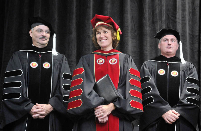 Laurie Gagnon Lachance, center, smiles during her inauguration as fifth president of Thomas College in Waterville, on Saturday. Thomas College board co-chairmen Conrad L. Ayotte, left, and Todd D. Smith, right, stand with the new president.
