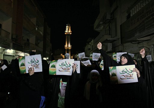 Bahraini women chant outside a religious community center in Sanabis, Bahrain, as they listen to top Shiite cleric Sheik Isa Qassim speak Thursday, about a film made in the United States that sparked violence against U.S. embassies in Egypt, Libya and Yemen. Qassim, whose speech was projected on monitors to overflow crowds outside, urged Western nations to stop extremists from insulting Islam's Prophet Muhammad, saying freedom of expression should not include insulting other faiths. The signs read: "We sacrifice ourselves," referring to Prophet Muhammad.