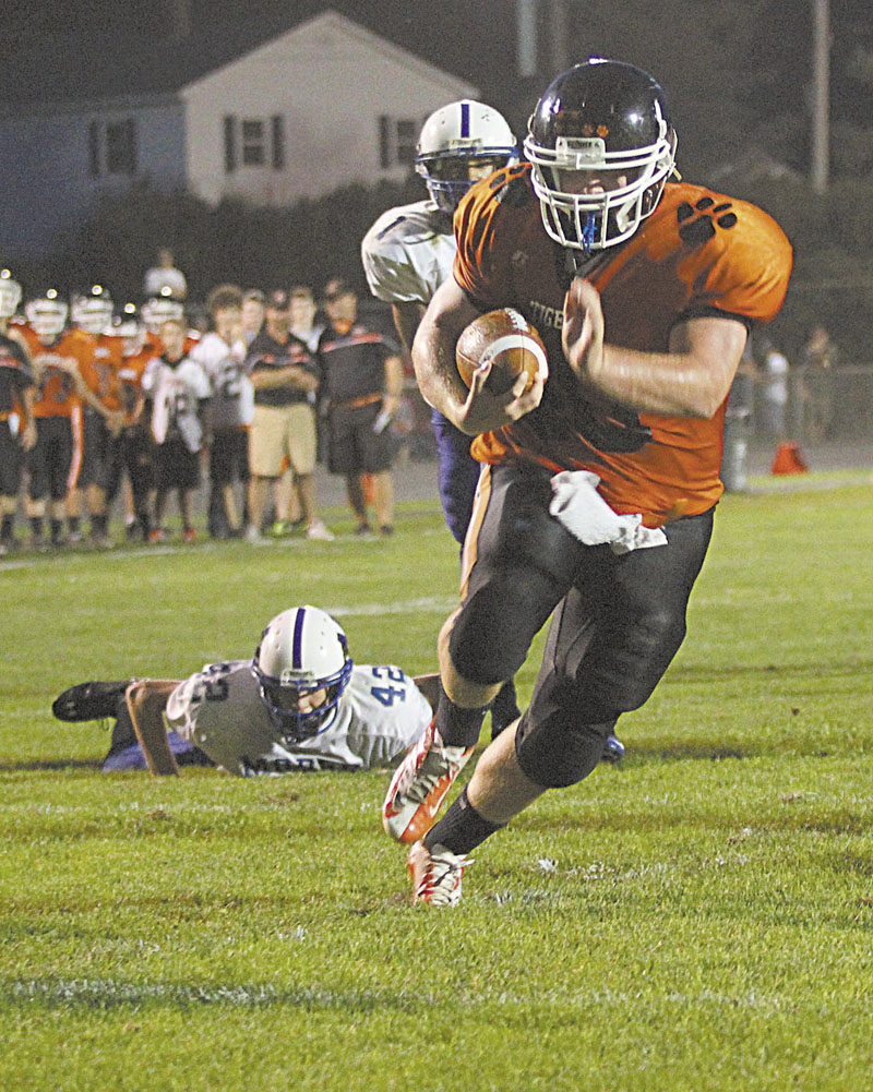 Photo by Jeff Pouland FINDING THE ENDZONE: Gardiner Area High School's Seth Wing scampers into the endzone for a first-half touchdown during Friday's night's game in Gardiner against Morse High School. Looking on is Morse High School's Scott Peterson (42) and D'Vaughn Myers (1).