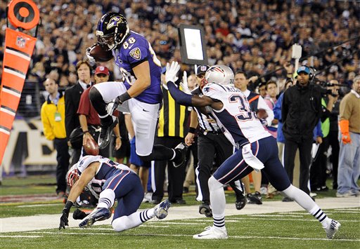 GETTING BY: Baltimore Ravens tight end Dennis Pitta (88) leaps past New England Patriots defenders Steve Gregory, bottom left, and Devin McCourty before scoring a touchdown in the first half Sunday night in Baltimore.