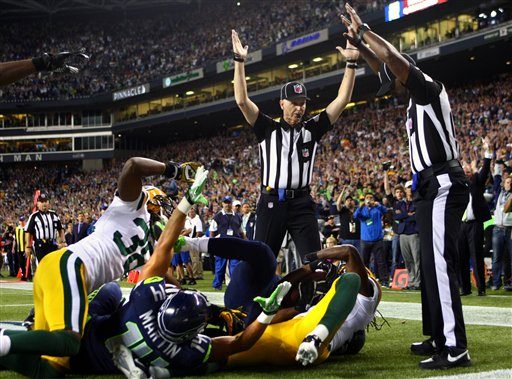 Officials signal after Seattle Seahawks wide receiver Golden Tate pulled in a last-second pass for a touchdown from quarterback Russell Wilson to defeat the Green Bay Packers 14-12 in an NFL football game, Monday, Sept. 24, 2012, in Seattle. The touchdown call stood after review. (AP Photo/seattlepi.com, Joshua Trujillo) MAGS OUT; NO SALES; SEATTLE TIMES OUT; TV OUT; MANDATORY CREDIT