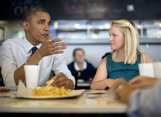President Barack Obama visits Emily Young, first time voter, and student and University of Miami at OMG Burger, Thursday, Sept. 20, 2012, in Miami, Fla. (AP Photo/Carolyn Kaster)