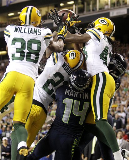 Green Bay Packers cornerbacks Tramon Williams (38) and Charles Woodson (21) and safety M.D. Jennings (43) fight for possession of a jump ball with Seattle Seahawks wide receivers Charly Martin (14) and Golden Tate, right, in the final seconds of the fourth quarter of an NFL football game, Monday, Sept. 24, 2012, in Seattle. Tate was ruled to have come down with the ball for a touchdown, and the Seahawks won 14-12. (AP Photo/Stephen Brashear) NFLACTION12;