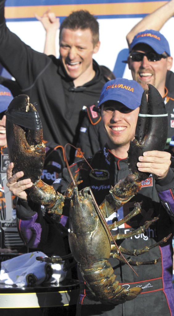 QUITE A PRIZE: Denny Hamlin holds up a lobster in victory lane after winning the NASCAR Sprint Cup race Sunday at New Hampshire Motor Speedway in Loudon, N.H.