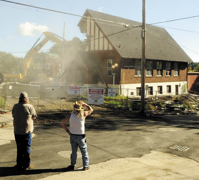 John Cash, left, and Jay Rice watch as excavators tear down the Augusta Spiritualist Church, at the corner of Court and Perham streets, Thursday morning to make way for the expansion of Kennebec County court complex.