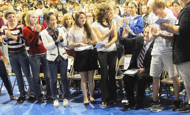 Staff photo by Joe Phelan Gov. Paul LePage, seated right, high fives Kat Newcombe while he receives a standing ovation following his speech on Wednesday afternoon at Erskine Academy in China. Gov. LePage spoke about domestic abuse and violence.