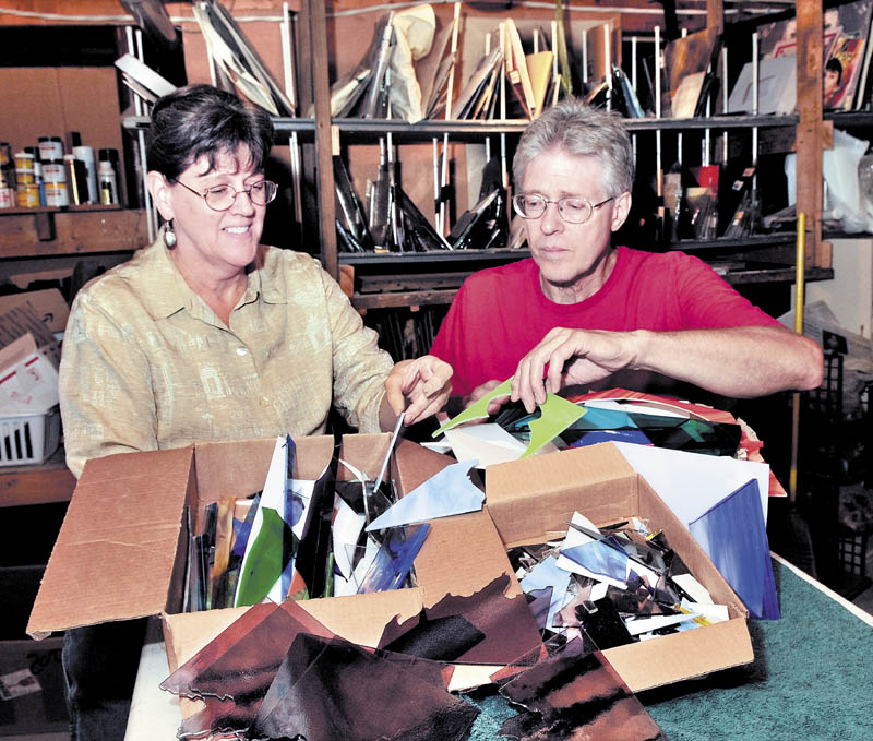 Staff photo by David Leaming SHARP: Lucy Boucher and Bernie Huebner pack boxes with scrap glass left from glass artwork made at their Stone Ridge Glass studio in Waterville. The couple are offering four-pounds of scrap glass to artists who will then make artwork for an exhibit at the Stained Glass Express on Oct. 20.