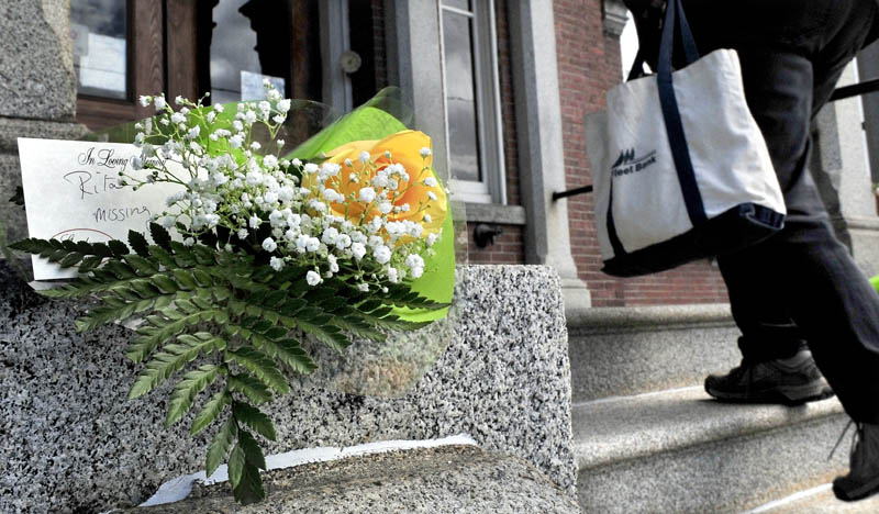 People walk into the Somerset County Superior Court in Skowhegan on Monday past flowers left in memory of Rita St. Peter who was killed 32 years ago. Jay Mercier has been charged in the murder and is on trial this week.