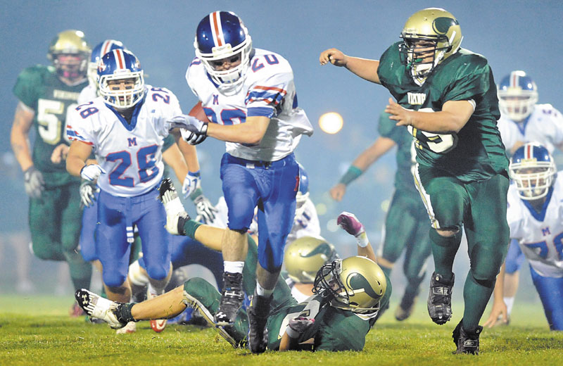 BREAKING AWAY: Messalonskee running back Corey McKenzie, center, breaks away from Oxford Hills defender Nick Bowie, back center, in the first quarter Friday night in South Paris.