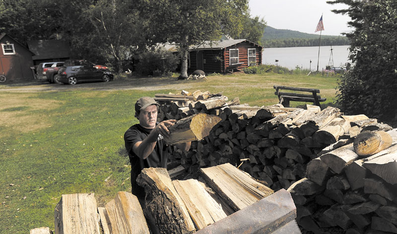 Dana Black moves wood into a bucket loader at Spencer Pond Camps, Friday. In addition to running the camps with his wife, Christine Howe, Black is also a lobsterman in Blue Hill.