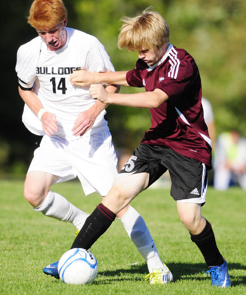 FIGHTING FOR POSSESSION: Hall-Dale’s Colin Lush, left, and Monmouth Academy’s Josh Reny go after a loose ball during a game Thursday afternoon at Hall-Dale High School in Farmingdale. The Bulldogs won 7-1.