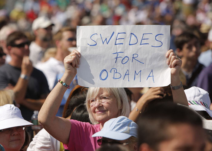A woman holds a "Swedes for Obama" sign in a field at the Strawbery Banke Museum in Portsmouth, N.H., hours before the scheduled arrival of President Obama, first lady Michelle, Vice President Joe Biden and Jill Biden.