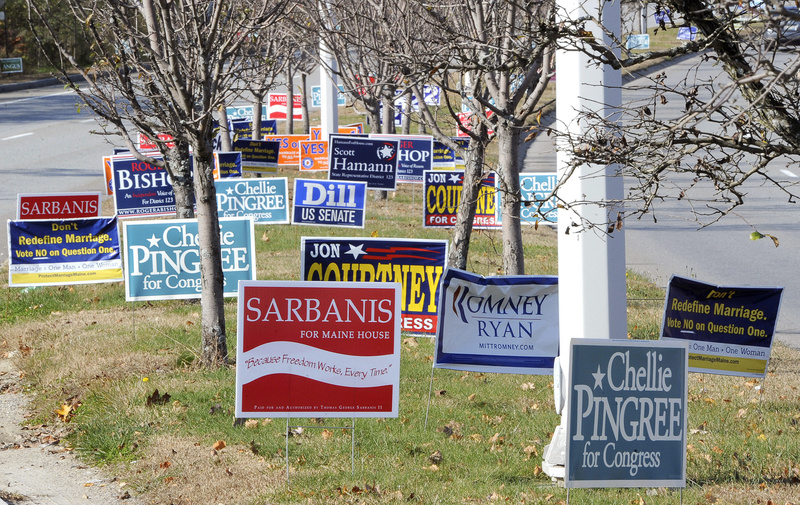 Dozens of political signs line the median along the approach to the Casco Bay Bridge in South Portland on Friday. Local sign makers say simple is best, and the fewer words, the better.