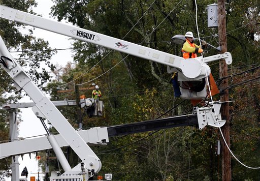 FILE - This photo taken Oct. 30, 2012, shows a utility crew working on damaged power lines in the aftermath of superstorm Sandy in Berlin, Md. One week before a close election, superstorm Sandy has confounded the presidential race, halting early voting in many areas, forcing both candidates to suspend campaigning and leading many to ponder whether the election might be postponed. It could take days to restore electricity to all of the more than 8 million homes and businesses that lost power when the storm pummeled the East Coast. That means it�s possible that power could still be out in some states on Election Day _ a major problem for areas that rely on electronic voting machines. (AP Photo/Alex Brandon)