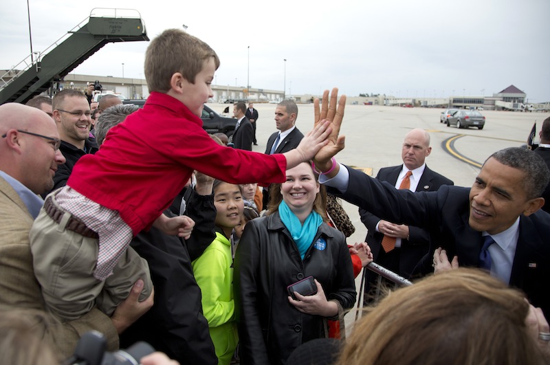 President Barack Obama high-fives a boy as he greets people on the tarmac as he arrives at Eastern Iowa Airport, Wednesday, Oct. 17, 2012, in Cedar Rapids, Iowa for a campaign stop. The president sports a pink bracelet in honor of October being breast cancer awareness month. (AP Photo/Carolyn Kaster)