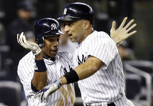 New York Yankees' Curtis Granderson, left, celebrates with Raul Ibanez after scoring on Ibanez's ninth-inning, two-run home run during their baseball game against the Boston Red Sox at Yankee Stadium in New York, Tuesday, Oct. 2, 2012. The Yankees won 4-3 in the 12th inning. (AP Photo/Kathy Willens)